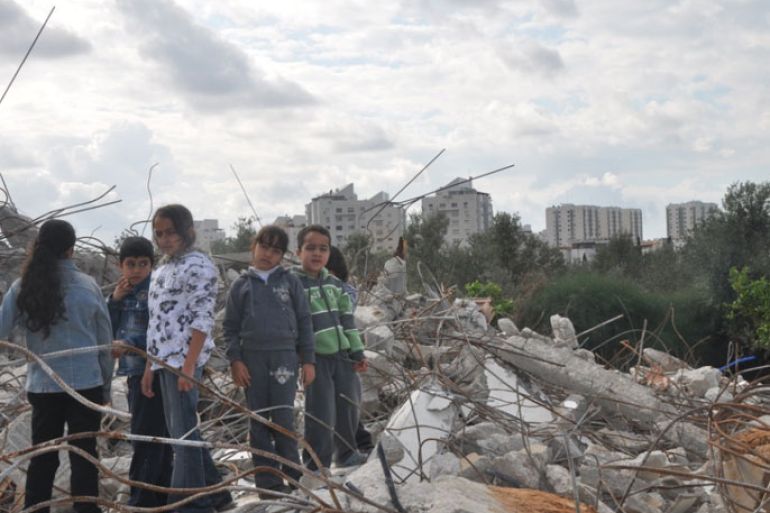 أطفال عائلة أبو عيد من الرملة على أنقاض ركام منازلهم المهدمة