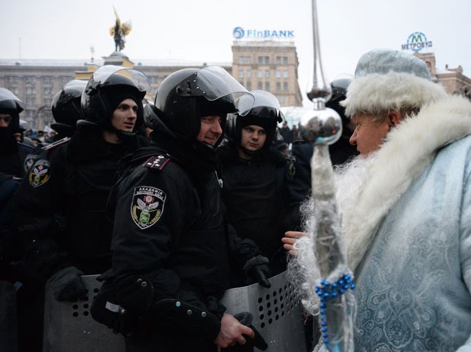 Kiev, -, UKRAINE : A man dressed as Santa Claus addresses the police on Independence Square in Kiev on December 11, 2013. Ukrainian security forces on December 11 stormed Kiev's Independence Square which protesters have occupied for over a week but the demonstrators defiantly refused to leave and resisted the police in a tense standoff. Eite Berkut anti-riot police and interior ministry special forces moved against the protestors at around 2:00 am (midnight GMT) in a move that prompted US Secretary of State John Kerry to express "disgust" over the crackdown. AFP PHOTO/VASILY MAXIMOV