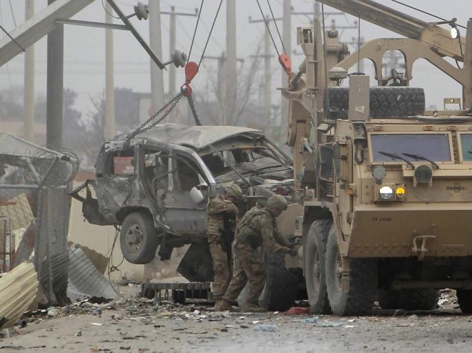 U.S. trucks lift up an armoured vehicle hit by a bomb attack in Kabul December 27, 2013. A suspected suicide bomber attacked a foreign military convoy on the eastern outskirts of the Afghan capital, Kabul, on Friday, killing at least three foreign soldiers, police and the NATO-led International Security Assistance Force (ISAF) said. REUTERS/Omar Sobhani (AFGHANISTAN - Tags: CIVIL UNREST POLITICS MILITARY TPX IMAGES OF THE DAY)