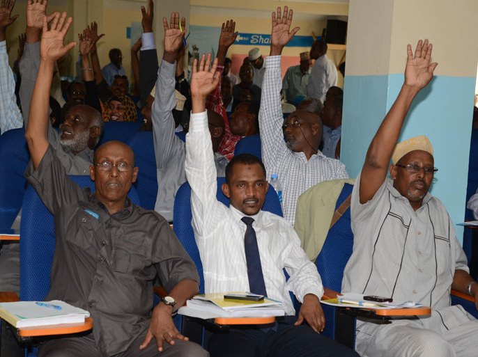 ABD04 - Mogadishu, -, SOMALIA : Somali lawmakers raise their hands on December 2, 2013 during a parliament session in Mogasishu to impeach Somali Prime Minister Abdi Farah Shirdon, who lost a no-confidence vote in parliament. Shirdon was ousted by parliament on December 2 amid a bitter power struggle within the internationally-backed government. Shirdon, prime minister of the Horn of Africa nation for just over a year, lost a confidence vote in parliament after he resisted President Hassan Sheikh Mohamud's demand that he resign. AFP PHOTO / Mohamed Abdiwahab