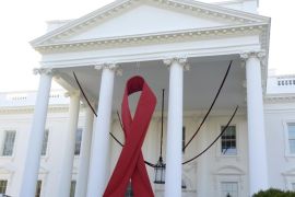 A giant red ribbon hangs from the North Portico of the White House to mark World AIDS Day, December 1, 2013, in Washington. REUTERS/Mike Theiler (UNITED STATES - Tags: POLITICS ANNIVERSARY)