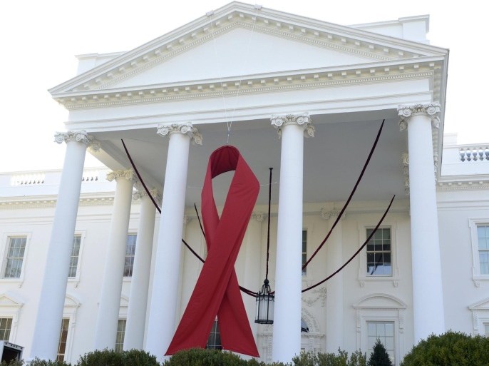 A giant red ribbon hangs from the North Portico of the White House to mark World AIDS Day, December 1, 2013, in Washington. REUTERS/Mike Theiler (UNITED STATES - Tags: POLITICS ANNIVERSARY)