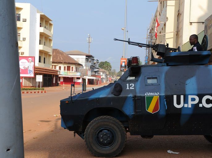 Bangui, -, CENTRAL AFRICAN REPUBLIC : Members of a police unit of the African-led International Support Mission in the Central Africa (MISCA) patrol near the presidential palace on December 5, 2013 in Bangui as shots rang out and blasts from heavy weapons rocked several districts of the Central African capital this morning amid communal tensions ahead of a UN vote authorising force to stop the country's descent into chaos. The incidents came as the UN Security Council was set to vote today on a measure authorising thousands of African and French troops to end anarchy in the Central African Republic, where massacres have led to warnings of genocide-style strife. AFP PHOTO / SIA KAMBOU