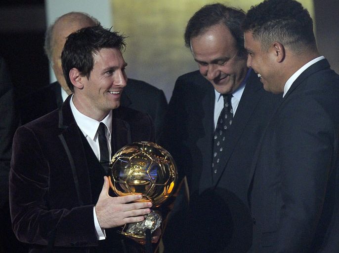 epa03054697 Lionel Messi of Argentina, (L) holds with the trophy next to UEFA chief Michel Platini (C) and former Brazilian soccer player Ronaldo (R) after winning the men's FIFA Ballon d'Or 2011 prize during the FIFA Ballon d'Or 2011 gala held at the Kongresshaus in Zurich, Switzerland, 09 January 2012. EPA/STEFFEN SCHMIDT