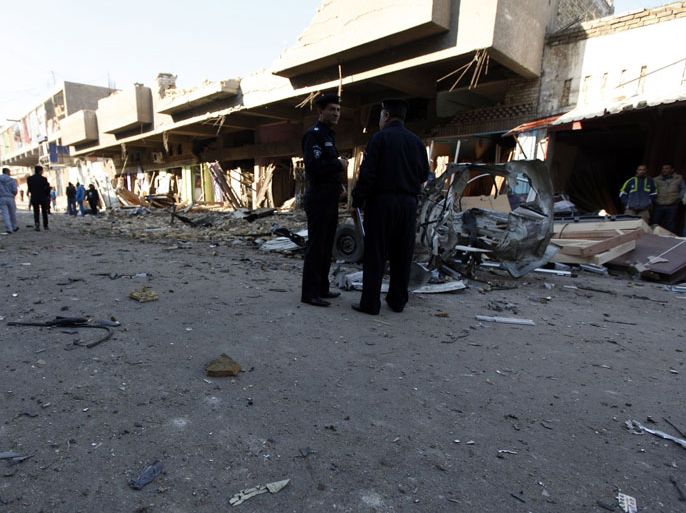 Iraqi policemen inspect the site of car bomb attack in Baghdad December 16, 2013. A series of suicide bombings and car and roadside bombs across Iraq killed at least 17 people on Monday, medical and police sources said. REUTERS/Ahmed Saad (IRAQ - Tags: CIVIL UNREST CRIME LAW)