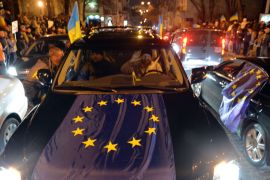 SUP-1012 - Kiev, -, UKRAINE : Cars decorated with EU and Ukrainian flags greet protesters during a rally on Mykhayllivska Square in Kiev after police dispersed protesters on Independence Square on November 30, 2013. Ukraine's opposition vowed on December 1, 2013 to defy a sudden ban on protests in central Kiev and rally in support of early elections after President Viktor Yanukovych rejected a historic EU pact. The ex-Soviet nation of 46 million was thrown into its deepest crisis since the 2004 pro-democracy Orange Revolution after Yanukovych snubbed EU leaders at a Vilnius summit and opted to keep Ukraine aligned with its former master Russia. AFP PHOTO/ SERGEI SUPINSKY