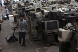 An employee pushes a cart next to discarded electronics at the Coopermiti warehouse in Sao Paulo March 6, 2013. According to the United Nations Environment Programme (UNEP), Brazil generates the greatest amount of electronic waste (e-waste) per capita among emerging countries. Coopermiti is an e-waste cooperative formed in 2010 that sorts through technological trash and develops solutions for breaking it down for the purposes of recycling. At the same time, Coopermiti offers opportunities for employment and environmental education for the community. About four tonnes of circuit boards, found amongst the e-waste, are sent to Dowa Holdings Co. Ltd. in Japan each month, from which rare metals may be recovered. REUTERS/Nacho Doce (BRAZIL - Tags: BUSINESS ENVIRONMENT EMPLOYMENT SCIENCE TECHNOLOGY)