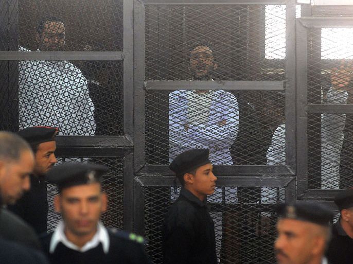 Egyptian activicts Mohamed Adel (L), Ahmed Douma (C) and Ahmed Maher (R) stand in the accused dock during their trial on December 22, 2013 in the capital Cairo. An Egyptian court sentenced three activists who spearheaded the 2011 uprising against Hosni Mubarak to three years in jail for organising an unlicensed protest, judicial sources said. It was the first such verdict against non-Islamist protesters since the overthrow of president Mohamed Morsi in July, and was seen by rights groups as part of a widening crackdown on demonstrations by military-installed authorities. AFP PHOTO/STR