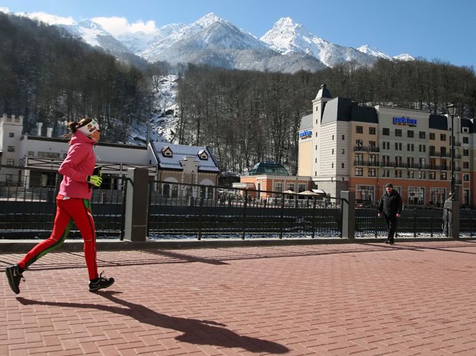 epa03613213 A picture made available 07 March 2013 shows a wintersports tourists jogging along the promenade in the Russian alpine ski resort Roza Khutor, one of the tourist villages outside Krasnaya Polyana winter resort in the Western Caucasus mountains near Sochi, Russia, 06 March 2013. The region presently hosts the Biathlon World Cup from 07 to 10 March 2013 and is a mountain venue of the upcoming 2014 Winter Olympics. EPA/SERGEI CHIRIKOV