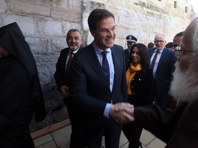 epa03980845 Mark Rutte, Prime Minister of The Netherlands, (C ) meets with clergy at the entrance to the Church of the Nativity, the traditional birthplace of Jesus Christ, as he tours the sites in Bethlehem, West Bank, 07 December 2013. EPA/ABED AL HASHLAMOUN