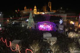 BETHLEHEM, WEST BANK, - : A view of Manger Square and the Church of the Nativity as people gather for Christmas eve celebrations in the biblical West Bank city of Bethlehem, believed to be the birthplace of Jesus Christ, on December 24, 2013. Thousands of Palestinians and tourists were flocking to Bethlehem to mark Christmas. TOPSHOTS/AFP PHOTO/HAZEM BADER