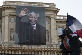 epa03979037 Workers remove French flags from the front entrance of the Quai d'Orsay foreign affairs ministry adorned by a giant portrait of the late Nelson Mandela, in Paris, France, 06 December 2013. Nobel Peace Prize winner Nelson Mandela died at age 95, in Johannesburg, South Africa, on 05 December 2013. A former lawyer, Mandela was the first black President of South Africa voted into power after the countries first free and fair democratic elections that witnessed the end of the Apartheid system in 1994. Mandela was founding member of the ANC (African National Congress) and anti-apartheid activist who served 27 years in prison, spending many of these