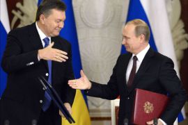 Russia's President Vladimir Putin (R) and Ukrainian President Viktor Yanukovych shake hands after signing documents during their meeting in the Kremlin in Moscow, on December 17, 2013. Putin said that the state energy companies of Russia and