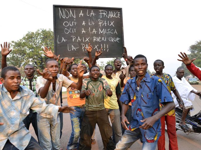 Bangui, -, CENTRAL AFRICAN REPUBLIC : Muslims from Bangui hold a sign reading "No to France - Yes to Peace - Yes to MISCA - Peace and only Peace !" as they protest against the French intervention called "Operation Sangaris" during a demonstration in a street of Bangui on December 22, 2013. Several thousand Muslims backing former Seleka rebels protested in the Central African Republic's capital today against French soldiers conducting a disarmament operation, AFP journalists in the city witnessed. AFP PHOTO / MIGUEL MEDINA