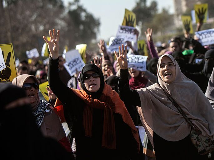 Supporters of the Muslim Brotherhood chant slogans and raise four fingers, the symbol known as "Rabaa", which means four in Arabic, remembering those killed in the crackdown on the Rabaa al-Adawiya protest camp in Cairo last year, during a demonstration in Cairo on January 24, 2014. A suicide bomber struck Cairo police headquarters on Friday, the first of three bombings in the Egyptian capital that killed five people ahead of the anniversary of the 2011 uprising. AFP PHOTO/MAHMOUD KHALED
