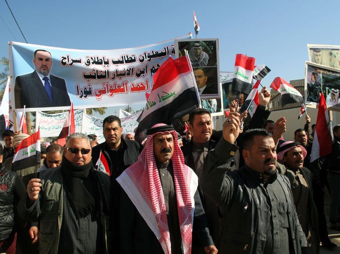 Ramadi, -, IRAQ : Iraqis shout slogans holding banners and national flags during a demonstration to ask for the release of Sunni Muslim MP Ahmed al-Alwani (on posters) on January 25, 2014 in Ramadi, west of Baghdad. Iraqi security forces raided on December 28, 2013 the home of al-Alwani, who backed anti-government protesters, arresting him and sparking clashes that killed his brother and five guards. Faced with a weeks-long standoff in Anbar province west of Baghdad and Iraq's worst protracted surge in violence since 2008, authorities have been urged by foreign leaders to pursue political reconciliation in a bid to undercut support for militants.