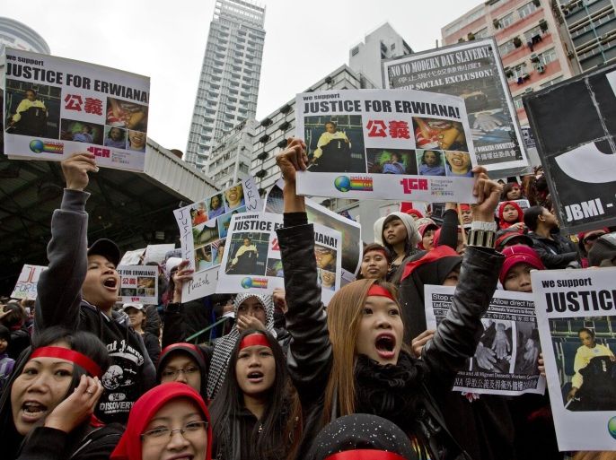 Domestic helpers and their supporters shout slogans while holding pictures of 23-year-old Indonesian maid Erwiana Sulistyaningsih during a protest in Hong Kong, Sunday, Jan. 19, 2014. The Indonesian maid who was allegedly brutally tortured by her employers for months has become the latest case to trigger outrage in Hong Kong over abuses commonly suffered by the city’s army of foreign migrant workers. Erwiana was allegedly assaulted for nearly eight months before the family she worked for sent her back to Indonesia. (AP Photo/Vincent Yu)