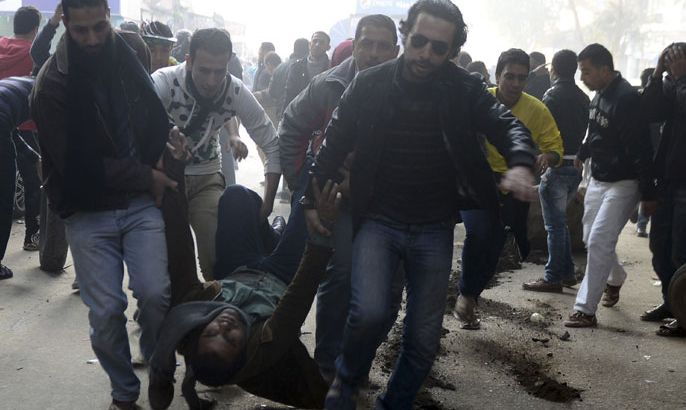 Supporters of the Muslim Brotherhood and ousted Egyptian President Mohamed Mursi carry an injured demonstrator who was shot during clashes in Cairo, on the third anniversary of Egypt's uprising, January 25, 2014. Twenty-nine people were killed during anti-government marches on Saturday while thousands rallied in support of the army-led authorities, underlining Egypt's volatile political fissures three years after the fall of autocrat President Hosni Mubarak. Security forces lobbed teargas and some fired automatic weapons in the air to try to prevent demonstrators opposed to the government reaching Tahrir Square, the symbolic heart of the 2011 uprising that toppled the former air force commander. REUTERS/Amr Abdallah Dalsh (EGYPT - Tags: POLITICS CIVIL UNREST ANNIVERSARY)