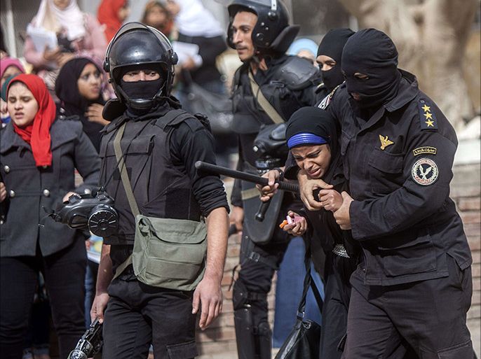 An Egyptian riot policeman detains a female student of al-Azhar University during a protest by students who support the Muslim Brotherhood inside their campus in Cairo on December 30, 2013. Egypt urged Arab League members to enforce a counter terrorism treaty that would block funding and support for the Muslim Brotherhood after Cairo designated it as "terrorist" group. AFP PHOTO/MAHMOUD KHALED