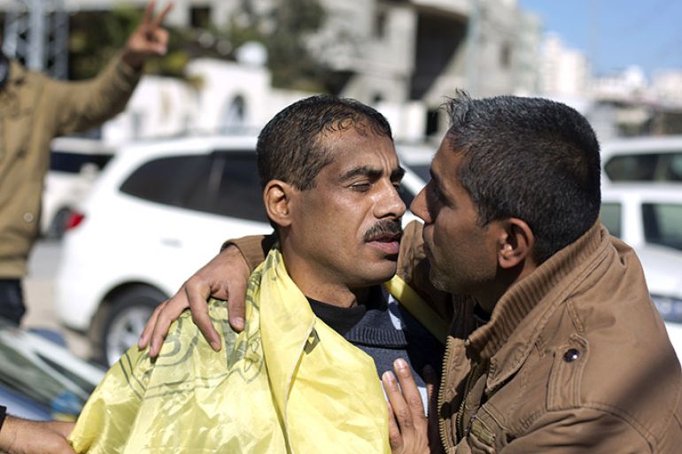 A Palestinian man (L) is hugged by a relative after he was freed from a Hamas-run jail in Gaza City, on January 8, 2014. Gaza's Hamas government freed seven members of the rival Palestinian Fatah group from its jails, in what it said was a goodwill gesture to enhance Palestinian unity and reconciliation, Hamas officials said. AFP PHOTO/MOHAMMED ABED