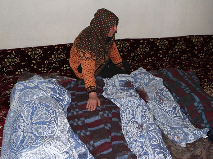 A woman mourn over the bodies of four children after they were killed when shells fired from war-torn Syria hit the Lebanese border town of Arsal in the Bekaa valley on January 17, 2014