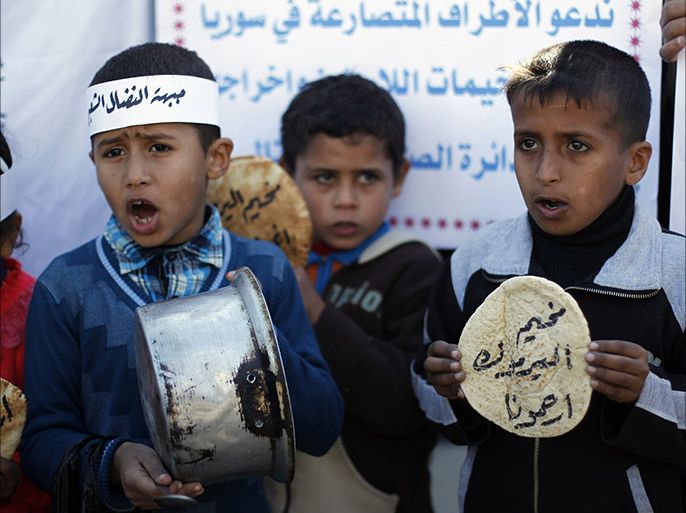 Palestinians children holds bread and pots on January 8, 2014, as they take part in a protest against the poor living conditions at the Yarmuk refugee camp in the Syrian capital Damascus, on January 8, 2014, in Rafah town in the southern Gaza Strip. UN Relief and Works Agency spokesman Chris Gunness told AFP on December 30, 2013,