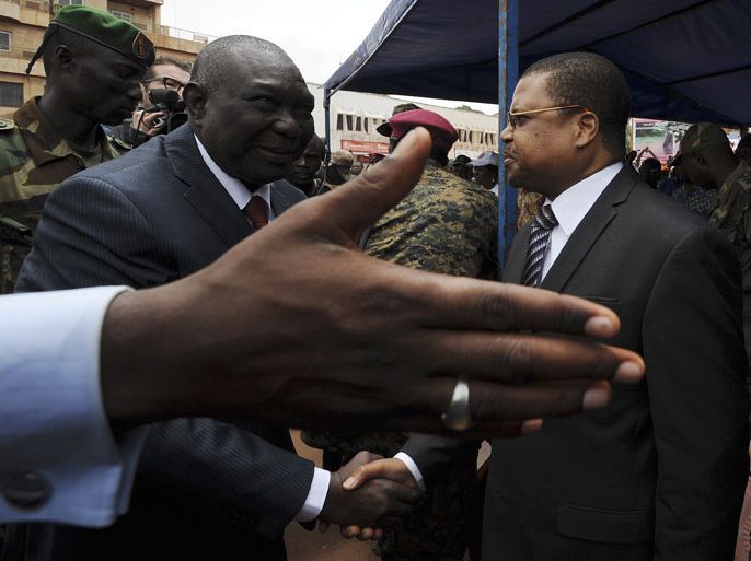 (FILES) This picture taken on March 30, 2013 shows Central African Republic leader Michel Djotodia (L) shaking hands with Prime Minister Nicolas Tiangaye on Republic Plaza in Bangui. Central African Republic President Michel Djotodia has resigned, a regional grouping announced on January 10, 2014 after intense pressure over his failure to stem deadly sectarian violence. The leaders of the Economic Community of Central African States (ECCAS) "noted the resignation" of Djotodia and Prime Minister Nicolas Tiengaye, said the statement from neighbouring Chad. AFP PHOTO / SIA KAMBOU