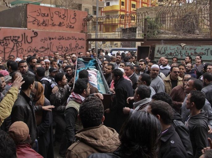 Egyptian relatives gather around the coffin of a man killed during Saturday's clashes between protesters and security forces at the Zeinhom morgue in Cairo, Egypt, Sunday, Jan. 26, 2014. Egyptian officials said Sunday that the death toll from clashes between security forces and protesters on the third anniversary of the country's 2011 uprising has risen to at least 49. (AP Photo/Aly Hazzaa, El Shorouk) EGYPT OUT