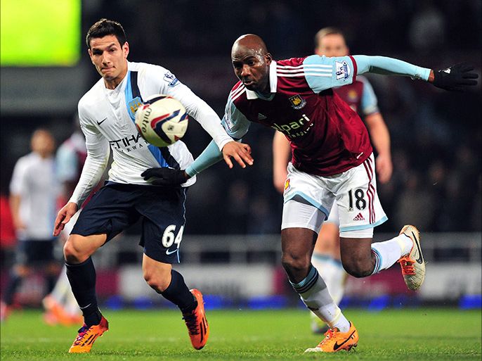 Manchester City's Portuguese midfielder Marcos Lopes (L) vies with West Ham United's French midfielder Alou Diarra (R) during the English League Cup semi-final second leg football match at the Boleyn Ground, Upton Park, in London on January 21, 2014. AFP PHOTO / GLYN KIRK
