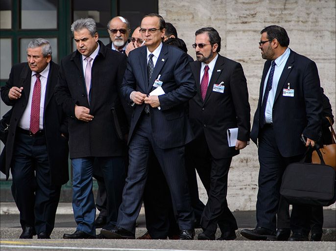 Syrian opposition chief negotiator Hadi al-Bahra (C) smokes a cigarette as he walks with a delegation outside the United Nations Offices on the second day of face-to-face peace talks in Geneva on January 26, 2014. Syria's regime and opposition are expected to discuss prisoner releases on the second day of face-to-face peace talks in Geneva. With no one appearing ready for serious concessions, mediators are focusing on short-term deals to keep the process moving forward, including on localised ceasefires, freer humanitarian access and prisoner exchanges. AFP PHOTO / FABRICE COFFRINI