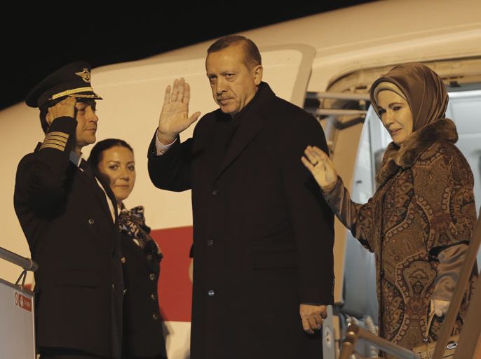 Turkish Prime Minister Tayyip Erdogan and his wife Emine Erdogan wave before their departure for Brussels at Esenboga Airport in Ankara January 20, 2014. Rocked by a corruption scandal, Turkey looks further than ever from its goal of European Union membership as Erdogan visits Brussels this week in the midst of a crackdown on the judiciary and police. Erdogan has purged hundreds of police and sought tighter control of the courts since a corruption inquiry burst into the open last month, a scandal he has cast as an attempted "judicial coup" meant to undermine him ahead of elections. REUTERS/Umit Bektas (TURKEY - Tags: POLITICS CRIME LAW BUSINESS)