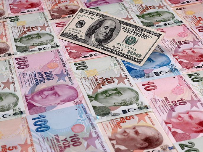 A file photo illustration taken on January 7, 2014 in Istanbul shows a 100 U.S. dollar banknote against Turkish lira banknotes of various denominations. Turkey's lira touched a new record low against the dollar on January 23, 2014, after the central bank left interest rates on hold and failed to meet market expectations