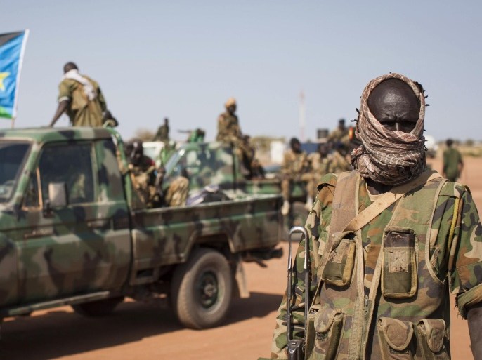 A South Sudanese government soldier stands with others near their vehicles, after government forces on Friday retook from rebel forces the provincial capital of Bentiu, in Unity State, South Sudan, Sunday, Jan 12, 2014. On Sunday senior South Sudanese government officers inspected the recaptured town of Bentiu, in northern Unity State, that was the scene of intense fighting between government and rebel forces, while a South Sudanese government official claimed rebels had badly damaged petroleum facilities in the state. (AP Photo/Mackenzie Knowles-Coursin)