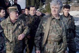 FILE - In this April 15, 1995 file photo, Bosnian Serb wartime leader, Radovan Karadzic, second right, and his general Ratko Mladic, first left, walk accompanied by bodyguards on Mount Vlasic frontline in Serbia. Mladic has slammed the United Nations' Yugoslav war crimes tribunal as a "satanic court" and refused to testify as a defense witness for his former political master Karadzic in the Hague, Netherlands, Tuesday, Jan. 28, 2014. A courtroom reunion of the two alleged chief architects of Serb atrocities during Bosnia's 1992-95 war, lasted only about an hour as Mladic told judges repeatedly he would not answer former Bosnian Serb President Karadzic's questions. (AP Photo/Sava Radovanovic, File)