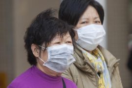 People wear protective face masks at the Queen Mary Hospital where an Indonesian domestic helper is in a critical condition after contracting the deadly H7N9 avian influenza virus, in Hong Kong, China, 04 December 2013. Scientists in Hong Kong have confirmed the territory's first human infection with a deadly strain of bird flu, officials said 03 December. Health authorities urged residents to avoid contact with live poultry and to seek medical attention for any influenza-like symptoms.