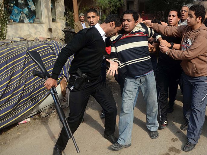 An Egyptian policeman arrests a Muslim Brotherhood supporter (C) following a demonstration in the Nasr City district of Cairo, on January 25, 2014. Egyptian police fired tear gas at anti-government protesters in Cairo, as the country marked the anniversary of a 2011 uprising that overthrew veteran president Hosni Mubarak. AFP PHOTO/MOHAMED EL-SHAHED