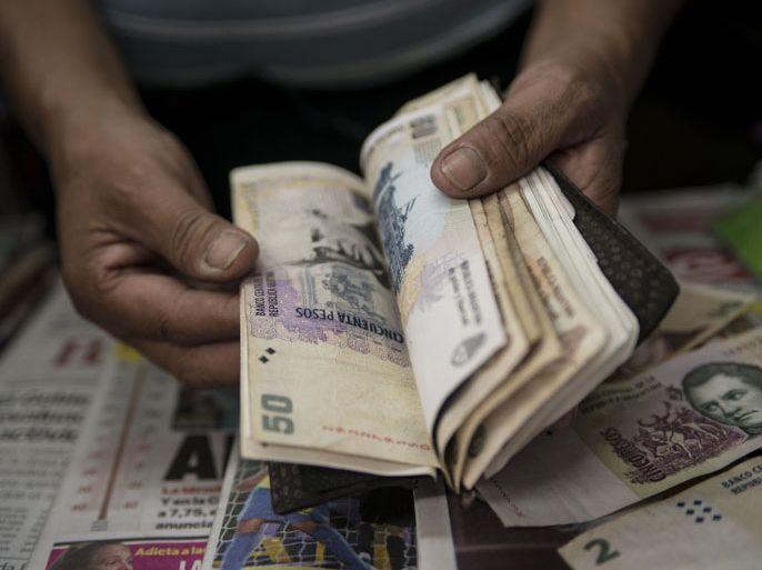 A newsstand owner counts Argentine pesos in Buenos Aires on January 24, 2014. Argentina on Friday