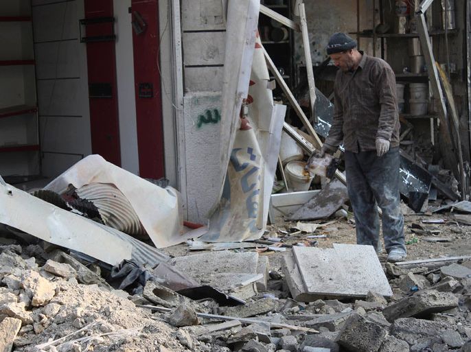 man inspects a damaged site after what activists said was shelling by forces loyal to Syria's President Bashar al-Assad in Al-Sukkari neighbourhood in Aleppo January 1, 2014. REUTERS/Hosam Katan (SYRIA