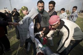 066 - GAZA CITY, GAZA STRIP, - : Palestinian carry a fellow protester wounded during clashes with Israeli forces following a protest near the Nahal Oz border crossing with Israel, east of Gaza City on January 17, 2014. AFP PHOTO/MOHAMMED ABED