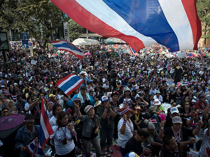 Thai anti-government protesters wave national flags, dance and sing songs at Ratchaprasong intersection during a rally in Bangkok on January 13, 2014