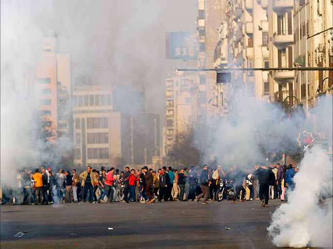 Anti-government protesters and members of the Muslim Brotherhood flee after teargas were fired by riot police during clashes at Ramsis street, which leads to Tahrir Square in downtown Cairo, on the third anniversary of Egypt's uprising, January 25, 2014. Seven people were killed during anti-government marches on Saturday while thousands rallied in support of the army-led authorities, underlining Egypt's volatile political fissures three years after the fall of autocrat president Hosni Mubarak. Security forces lobbed teargas and fired in the air to try to prevent demonstrators opposed to the government from reaching Tahrir Square, the symbolic heart of the 2011 uprising that toppled the former air force commander. REUTERS/Amr Abdallah Dalsh (EGYPT - Tags: POLITICS CIVIL UNREST ANNIVERSARY)