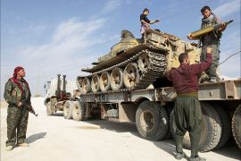 Members of Kurdish People's Protection Units (YPG) are seen on a military truck that belonged to the Islamist rebels after capturing it near Ras al-Ain, in this November 6, 2013 file photo. REUTERS/Stringer/Files (SYRIA - Tags: POLITICS CIVIL UNREST MILITARY)