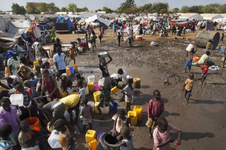 Displaced people gather around a water truck to fill containers at a United Nations compound which has become home to thousands of people displaced by the recent fighting, in the capital Juba, South Sudan Sunday, Dec. 29, 2013. Some 25,000 people live in two hastily arranged camps for the internally displaced in Juba and nearly 40,000 are in camps elsewhere in the country, two weeks after violence broke out in the capital and a spiralling series of ethnically-based attacks coursed through the nation, killing at least 1,000 people. (AP Photo/Ben Curtis)