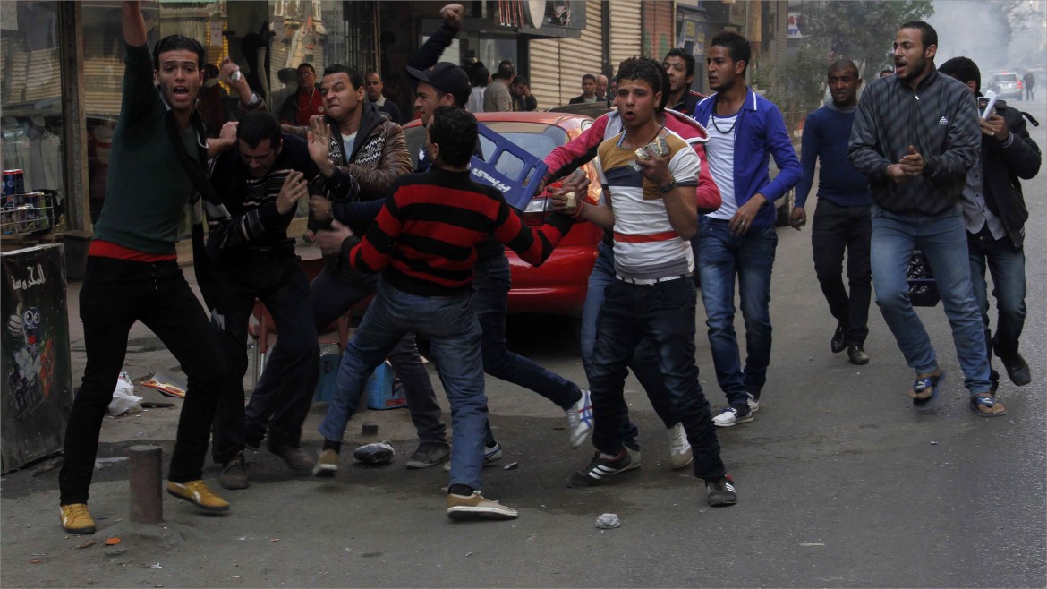 Cairo, -, EGYPT : A member of the 6th April movement (C-back) is attacked by supporters of Defence Minister army chief Abdel Fattah al-Sisi (front) in Cairo's Talaat Harb sqaure, near Tahrir square, on January 25, 2014 as clashes broke out during rival rallies on the anniversary of the 2011 revolt that toppled Hosni Mubarak, underscoring the country's polarisation three years after the uprising. A spate of deadly bombings put Egyptian police on edge as supporters and opponents of the military-installed government take part in rival rallies for the anniversary of the 2011 Arab Spring uprising. AFP PHOTO / KHALED KAMEL