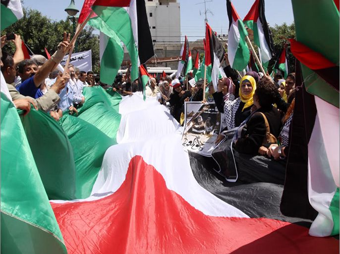 شباب فلسطيني يحمل العلم ويطالب بانهاء الانقسام في فعالية سابقة