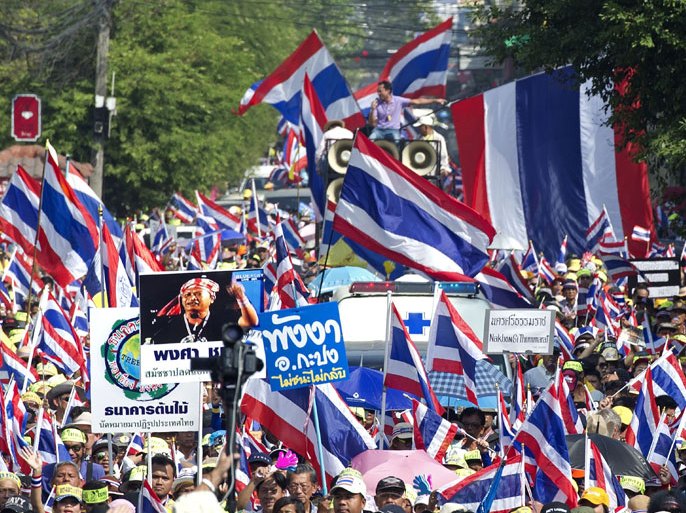Bangkok, -, THAILAND : Thai anti government protesters wave national flags during a rally in Bangkok on January 5, 2014. Thousands of Thai opposition protesters marched through Bangkok on January 5 to demand the prime minister step down, in a "warm-up" for their planned occupation of the city. AFP PHOTO / PORNCHAI KITTIWONGSAKUL