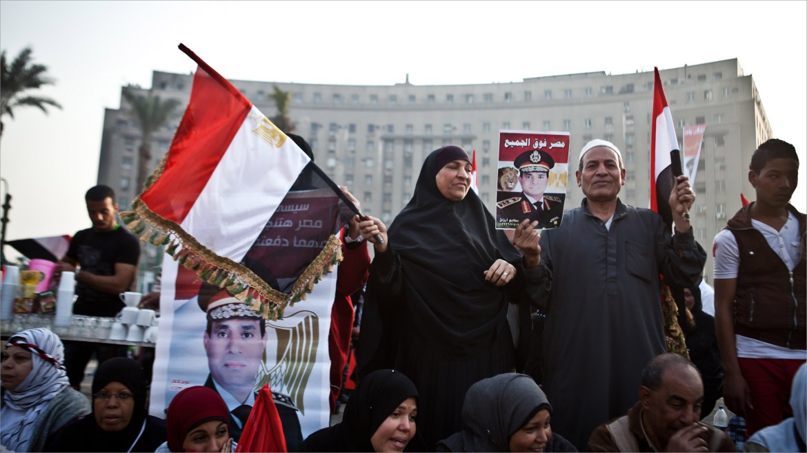 Cairo, -, EGYPT : Egyptians wave the national flag and hold up pictures of Defence Minister army chief Abdel Fattah al-Sisi in Cairo's Tahrir Square during a rally marking the anniversary of the 2011 Arab Spring uprising on January 25, 2014. A spate of deadly bombings put Egyptian police on edge as supporters and opponents of the military-installed government take part in rival rallies for the anniversary of the 2011 Arab Spring uprising. AFP PHOTO/VIRGINIE NGUYEN HOANG
