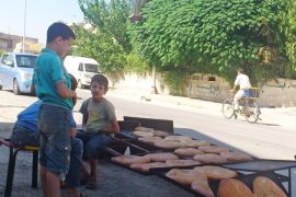 الطفل محمد وهو يبيع ربطا الخبز وبعض المعجنات ليعيل بعائلته - الجزيرة نت