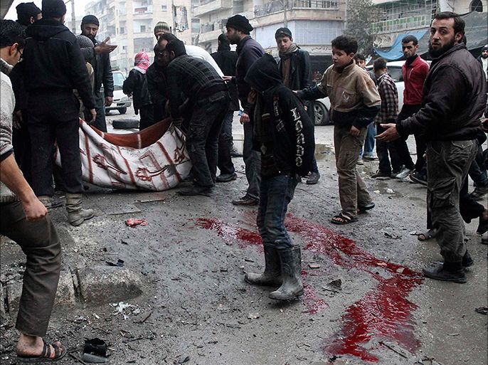 Blood stains are seen on the ground as men carry a casualty after what activists said was shelling by forces loyal to Syria's President Bashar al-Assad at Aleppo's Tariq al-Bab neighbourhood January 27, 2014. REUTERS/Hosam Katan (SYRIA - Tags: POLITICS CIVIL UNREST CONFLICT)