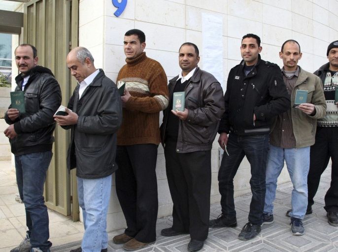 Egyptian men pose with their passports while queuing to enter their country's embassy to place their votes in a referendum on Egypt's new constitution in Amman January 9, 2014. Egyptians living outside the country on Wednesday began voting in the referendum on the new constitution. The referendum marks the first time Egyptians have voted since the removal of President Mohamed Mursi in July, and is seen as much as a public vote of confidence on the roadmap and army chief Abdel Fattah al-Sisi as the constitution itself. REUTERS/Majed Jaber (JORDAN - Tags: POLITICS ELECTIONS)